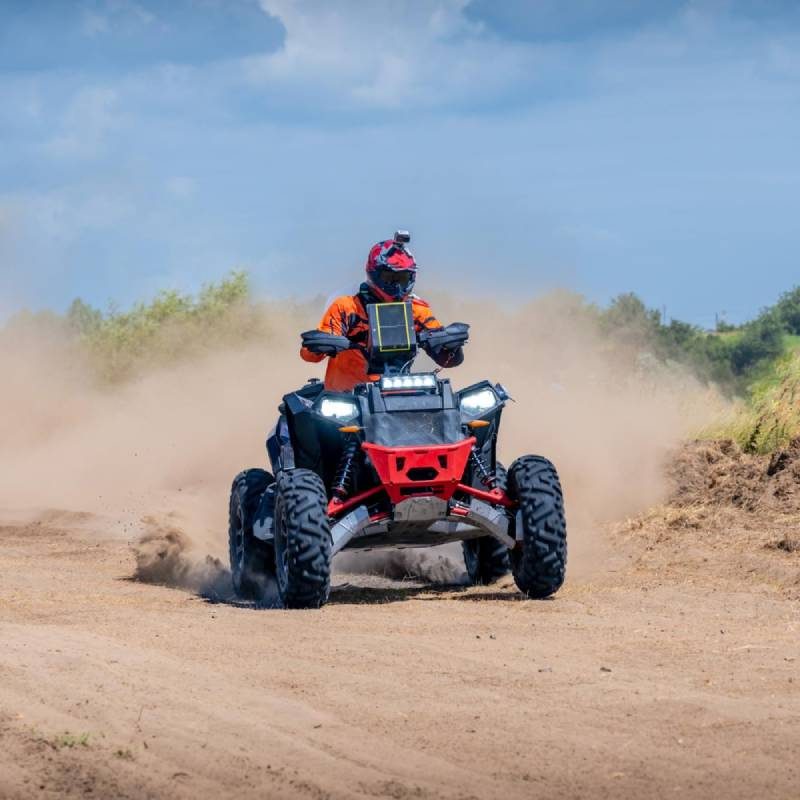 Quad avec une assurance provisoire roulant sur une piste en terre