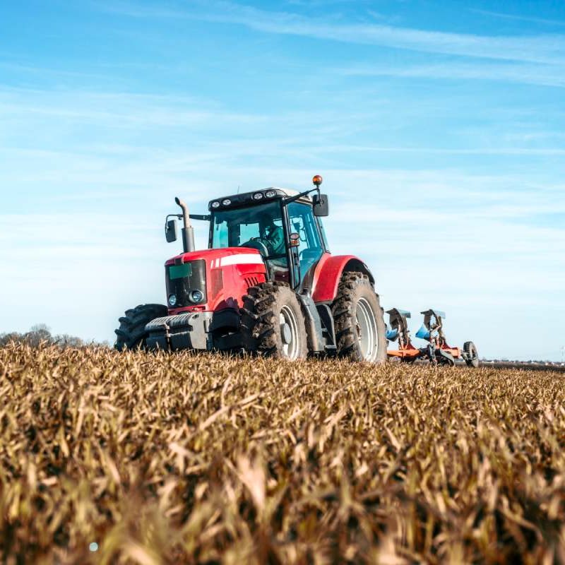 Tracteur agricole dans un champ avec une assurance temporaire