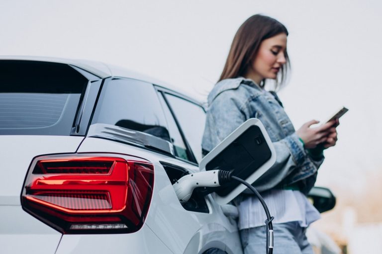 Une femme patiente pendant la charge de sa voiture